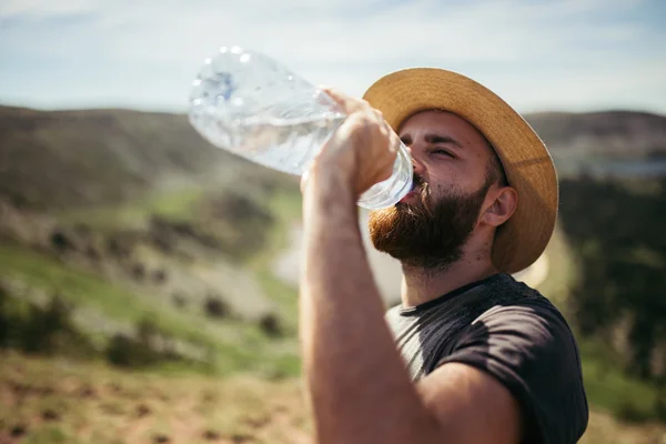 Человек пьет воду в природе Стоковое Фото