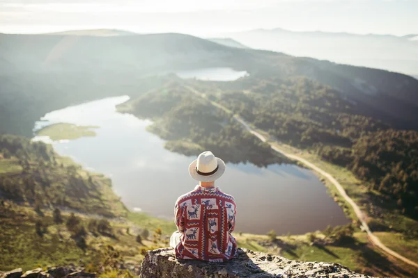 Man sitted in a rock looking Stock Picture