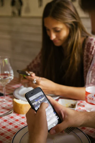 Teman mencari telepon di restoran — Stok Foto