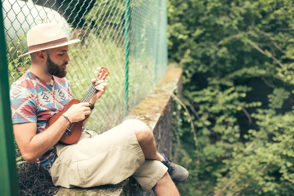 Man spelar ukulele i naturen — Stockfoto