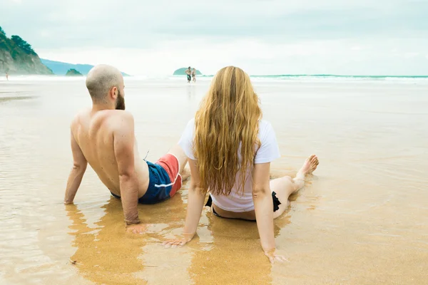 Friends seated in water — Stock Photo, Image