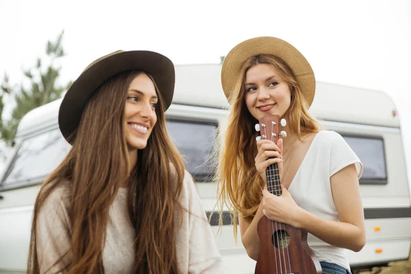 Duas meninas se divertindo jogando ukulele com uma van no bac — Fotografia de Stock