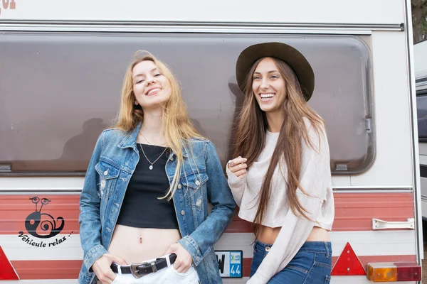 Dos chicas sonriendo apoyadas en una furgoneta . —  Fotos de Stock
