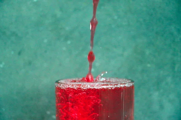 Effet de la goutte d'eau et du verre d'eau sur la table en bois devant le fond du mur de ciment — Photo