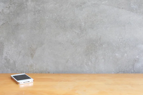 Çimento duvar arka plan önünde ahşap masa üstünde Smartphone 