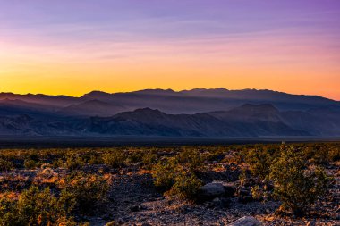 Death Valley Ulusal Parkı 'nın güzel manzarası. Batan güneşin yarattığı turuncu ve mor gökyüzü