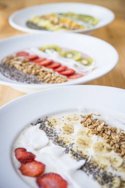 Üç farklı meyve gevreği, chia tohumu ve hindistan cevizli yoğurt karışımı.