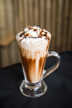 Ahşap zeminli ahşap bir masada buzlu kahve milkshake.