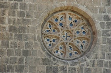 Kilisede dekoratif süslerle oyulmuş taş bir pencere.