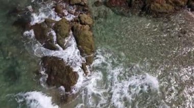 Deniz dalgaları kayalık kıyı şeridini yıkıyor.