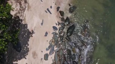 Kayalık kıyı şeridinde deniz dalgaları kırılan güzel görüntülerin hava aracı görüntüsü