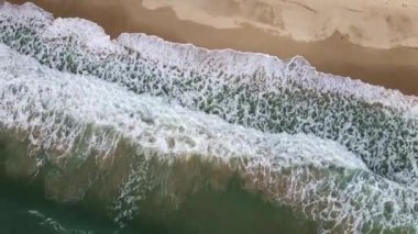 Turkuaz deniz dalgalarının kumlu sahil şeridinde dalgalandığı güzel görüntüler.