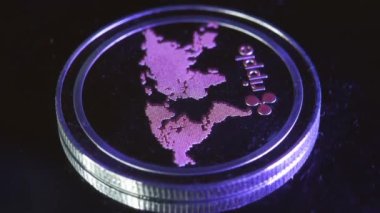 4K görüntü makro görüntüsü XRP dalgalı para birimi yavaş yavaş döner döner döner tabla kırmızı; yeşil; mavi ve mor ışık yansıtan
