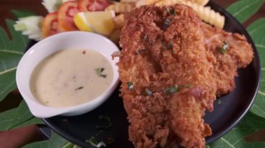 Bir tabak lezzetli balık ve patates kızartmasının 4K görüntüsü.
