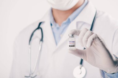 Covid-19 Corona virüsüne karşı yapılan kavramsal mücadele, laboratuvarda bulunan doktor ya da bilim adamı çocuk ya da daha yaşlı yetişkinler için sıvı aşı içeren bir şırınga taşıyor, kavram: hastalıklar, tıbbi bakım, bilim.