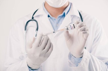 Covid-19 Corona virüsüne karşı yapılan kavramsal mücadele, laboratuvarda bulunan doktor ya da bilim adamı çocuk ya da daha yaşlı yetişkinler için sıvı aşı içeren bir şırınga taşıyor, kavram: hastalıklar, tıbbi bakım, bilim.