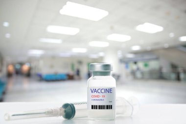 Covid-19 Corona virüsüne karşı yapılan kavramsal mücadele, laboratuvarda bulunan doktor ya da bilim adamı çocuk ya da daha yaşlı yetişkinler için sıvı aşı içeren bir şırınga taşıyor, kavram: hastalıklar, tıbbi bakım, bilim.