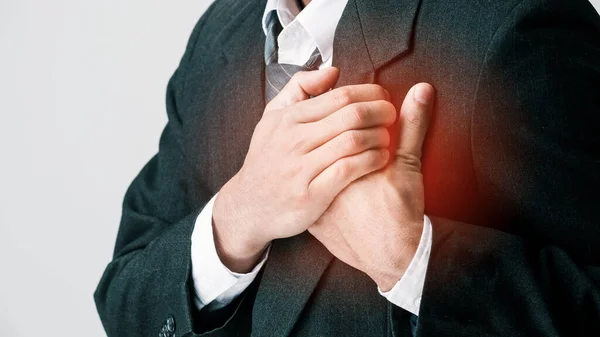 İş adamı akut acıdan göğsünü sıkıca tutuyor. Şiddetli kalp ağrısı, göğüs ağrısından muzdarip bir adam, kalp krizi ya da ağrılı kramplar, acı dolu bir ifadeyle göğsüne bastırıyor..