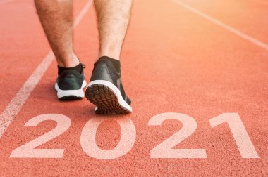Spor üniformalı adamlar etrafta koşuşturuyor. Sağlıklı bir yaşam tarzı ve aşılanmış bir vücut. Spor ayakkabıları yakın plan, 2020 'de bitir. Yeni yıla başla 2021 planları, hedefleri, hedefleri