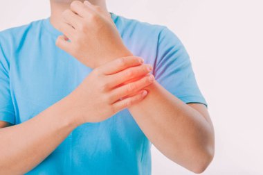 Kanepede oturan genç adam onun bileğini tutuyor. El yaralanması, acı hissetme. Sağlık ve tıbbi konsept. Fizyoterapist bilek kemiğine bastırarak hastanın bileğini kontrol eder. 