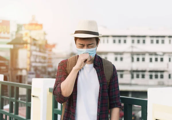 Man coughing.A man wearing a face mask because of air pollution in the city. wear N95 mask to protect PM 2.5 dust and Coronavirus disease (COVID-19)