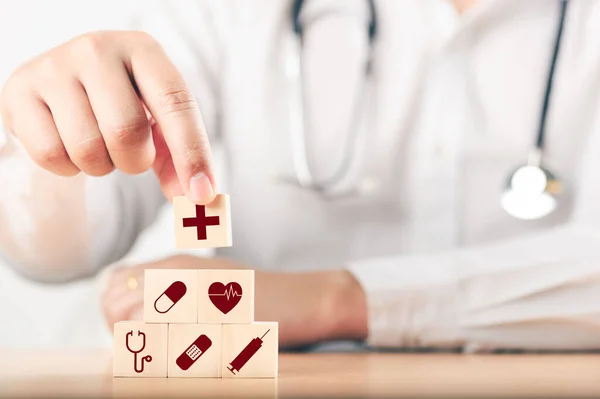 Elle düzenleme, ahşap bloklar, sağlık hizmeti ikonu ile istifleniyor. Sağlık sigortası - sağlık kavramı