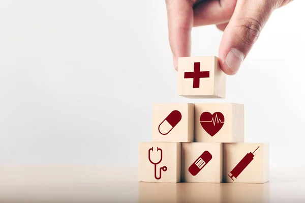Elle düzenleme, ahşap bloklar, sağlık hizmeti ikonu ile istifleniyor. Sağlık sigortası - sağlık kavramı