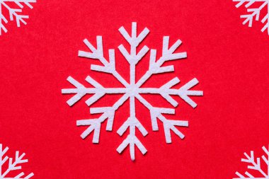 Kırmızı arka planda beyaz kar taneleri. Düz döşeme Noel süslemesi