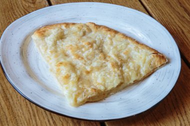 Peynirli büyük bir dilim pizza. Peynirli sıcak tortilla, Khachapuri, Kafkas mutfağı.
