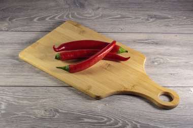 Kesme tahtasının üzerinde kırmızı biber kabukları.