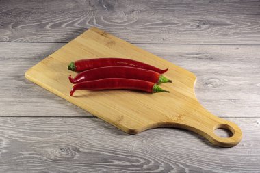 Kesme tahtasının üzerinde kırmızı biber kabukları.