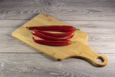 Kesme tahtasının üzerinde kırmızı biber kabukları.