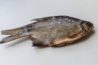 Beyaz arka plan üzerinde kurumuş tuzlu balık yakın çekim.