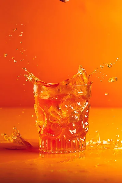 Cristal Tallado Sobre Fondo Naranja Con Salpicadura Líquido Naranja — Foto de Stock