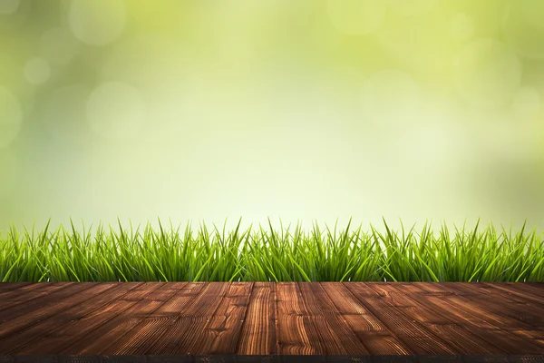 Suelo de madera, hierba y fondo borroso verde — Foto de Stock