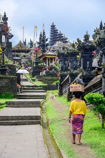 Balinese woman walk in traditional dress in Pura Besakih — Stock Photo, Image