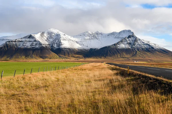 Strada e campo vuoti all'inizio dell'inverno dell'Islanda — Foto Stock