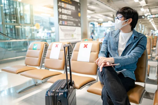 Turista Asiático Con Máscara Protectora Sentada Con Equipaje Maleta Terminal — Foto de Stock