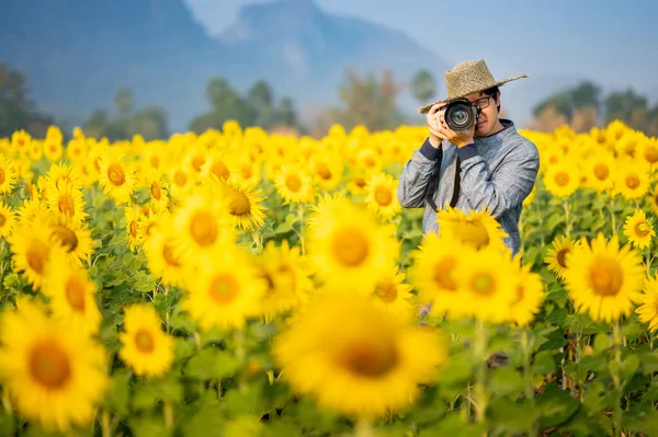 亚洲男子游客和摄影师手持Dslr相机 在泰国Lopburi拍摄黄花盛开的照片 夏季旅行概念 — 图库照片