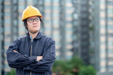 İnşaat alanında çalışan koruyucu giysili ve kasklı Asyalı tamirci. İnşaat mühendisliği, mimarlık, inşaat ve inşaat hizmeti kavramları.