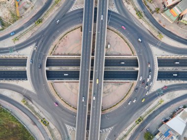 Kavşakla kavşağın hava görüntüsü. Hızlı giden arabalarla şehir otoyolu kavşağı. İnsansız hava aracı tarafından alınan ulaşım ağı.