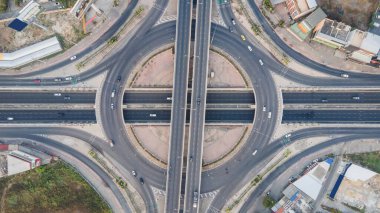 Kavşakla kavşağın hava görüntüsü. Hızlı giden arabalarla şehir otoyolu kavşağı. İnsansız hava aracı tarafından alınan ulaşım ağı.