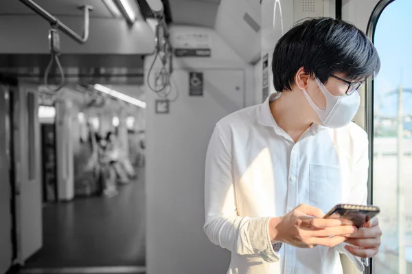 Aziatische Man Draagt Gezichtsmasker Met Behulp Van Smartphone Skytrain Stedelijke — Stockfoto