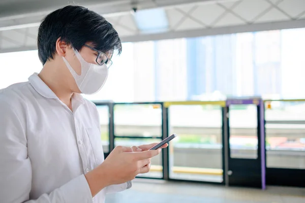 Aziatische Man Draagt Gezichtsmasker Met Behulp Van Smartphone Skytrain Station — Stockfoto