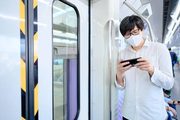 Pria Asia Mengenakan Masker Wajah Menggunakan Smartphone Skytrain Atau Kereta — Stok Foto