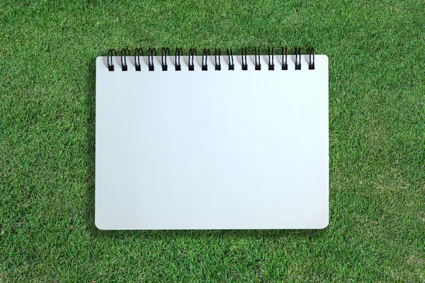 White page of notebook on grass texture — Stock Photo, Image