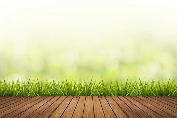 Gras mit grün verschwommenem Hintergrund und Holzboden — Stockfoto