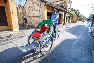 Man riding a traditional cyclo in Hoi An