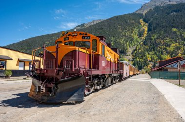 Durango ve Silverton dar buharlı tren durağı Silverton kasabasındaki sonbahar yeşillikleri sırasında güzel bir dağ manzarasının önünde. Colorado, ABD 'de klasik demiryolu taşımacılığı.