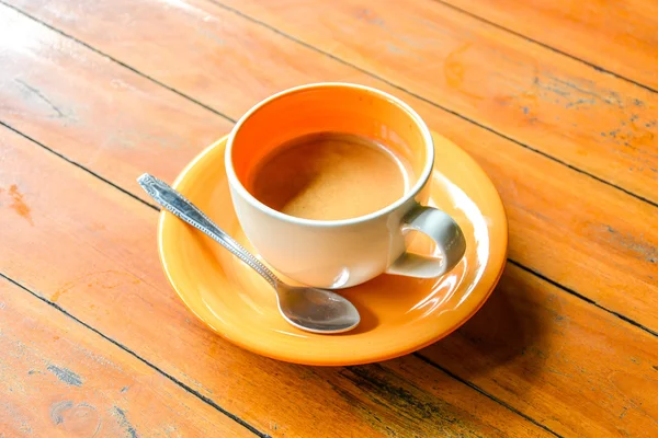 Coffee in ceramic orange cup on wooden table — Stock fotografie